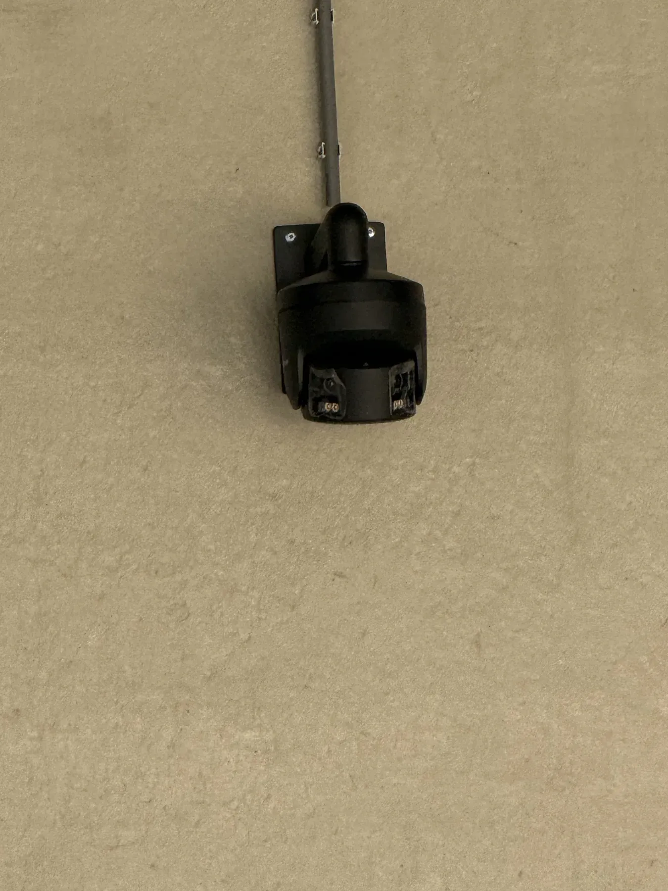 PTZ-camera op een uitschuifbare beugel aan een zandkleurige buitengevel